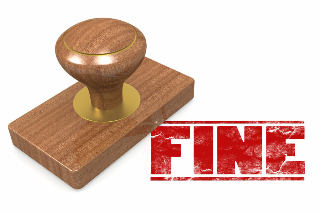 photo of wooden stamp with the word fine in red ink on paper